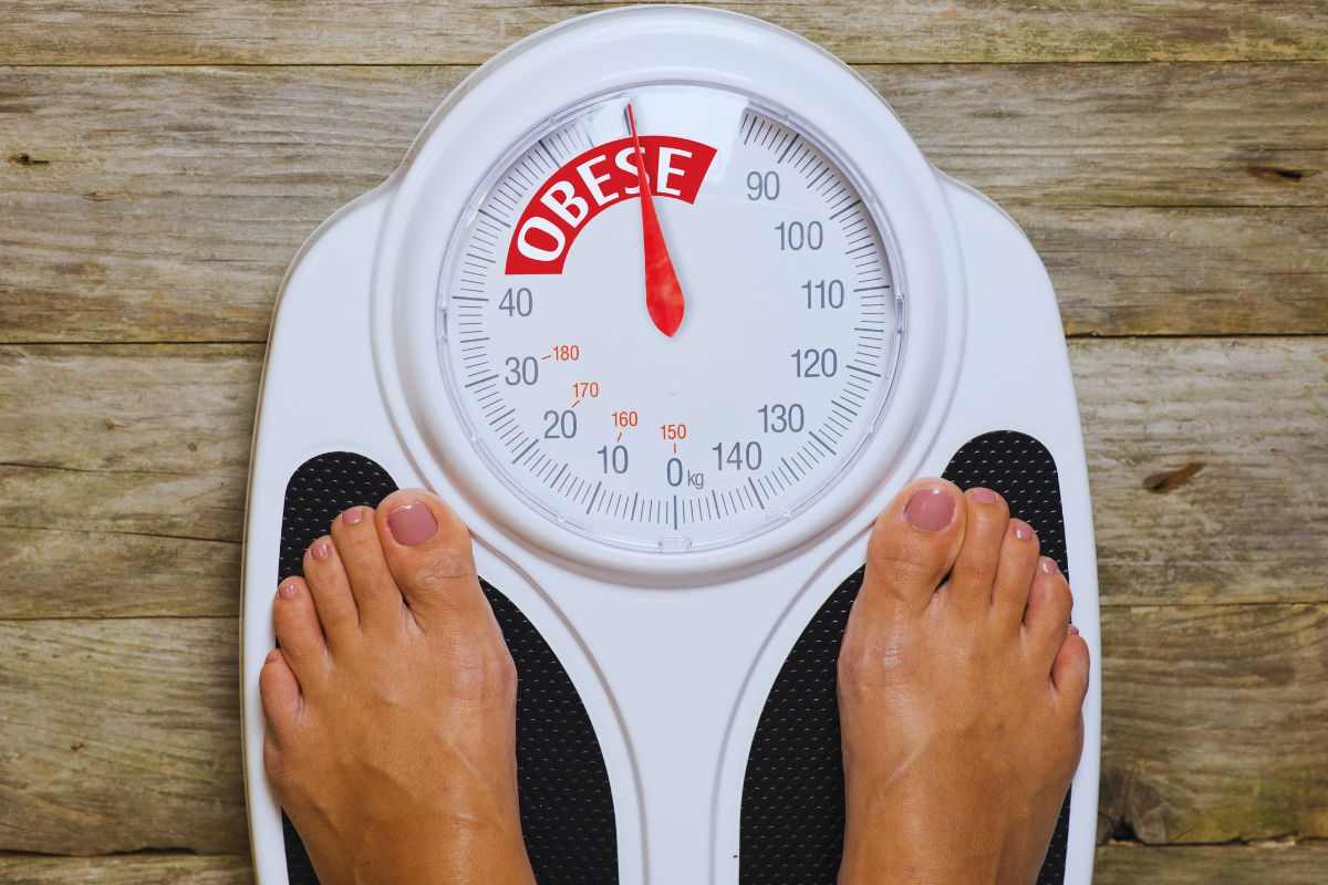 Donna che si pesa su bilancia