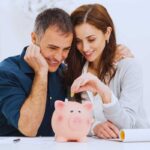 coppia che mette monete nel salvadanaio