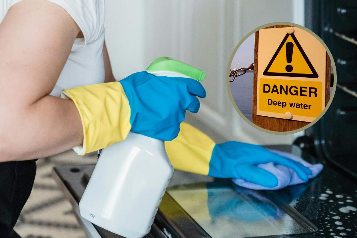 Una donna che pulisce un forno e, in evidenza, un segnale di pericolo