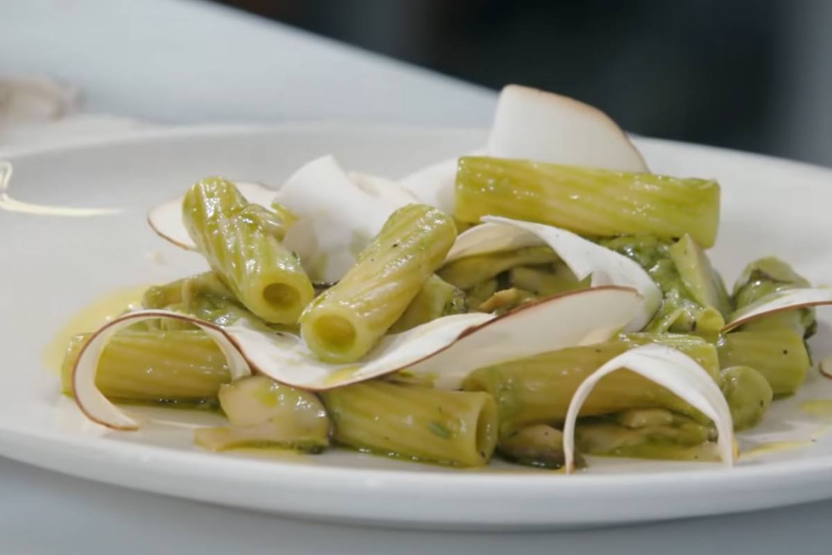 Piatto di pasta con salsa al pesto e funghi