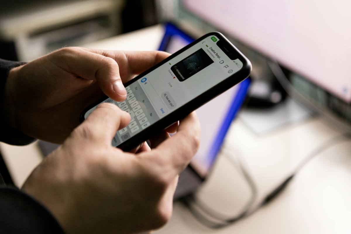 Un telefono collegato a WhatsApp tra le mani di un utente